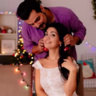young-beautiful-couple-man-hanging-christmas-balls-ears-her-girlfriend-having-fun-christmas-decorated-room-with-christmas-tree-background_141793-42985